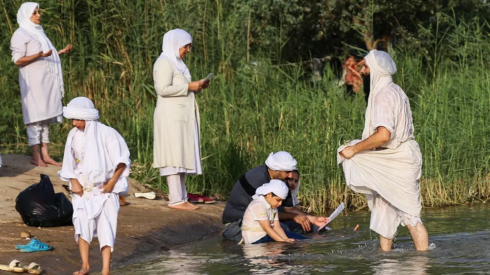 Mandaeans in white ritual dress at a baptism on the bank of the Karun River at Ahvaz