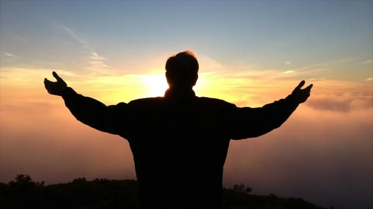 Prayer in the Abrahamic traditions: a worshipper with raised arms against the evening sky